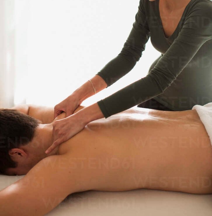 female-masseuse-giving-man-massage-HOXF04388 (1)